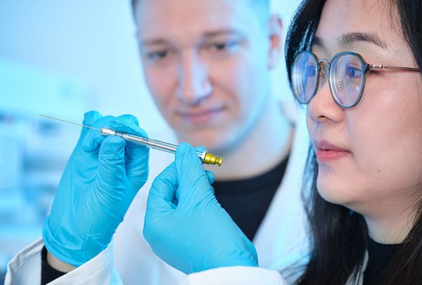 Researchers in a lab closely observing a PAL PFAS free Syringe used for contamination-free analysis