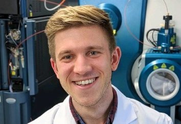 A picture of Dr. Hagen M. Gegner in front of mass spectrometers.